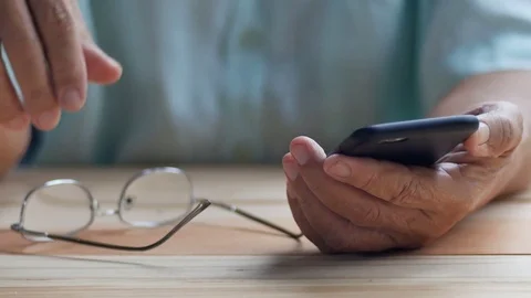 Old man with glasses hold black smartphone with left hand Stock Footage 80903576