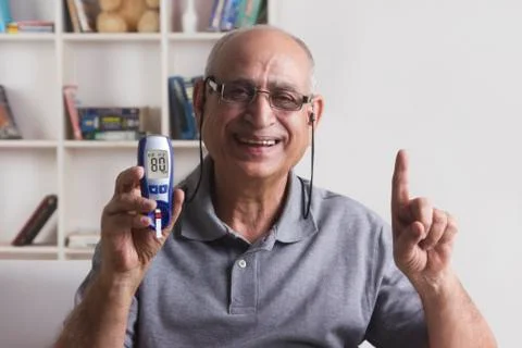 Old man with glucose meter gesturing Stock Photos