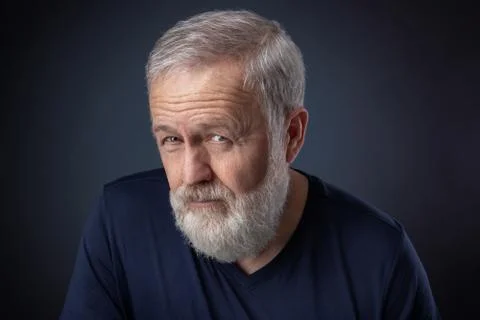 Old man with gray beard looking suspicious Stock Photos