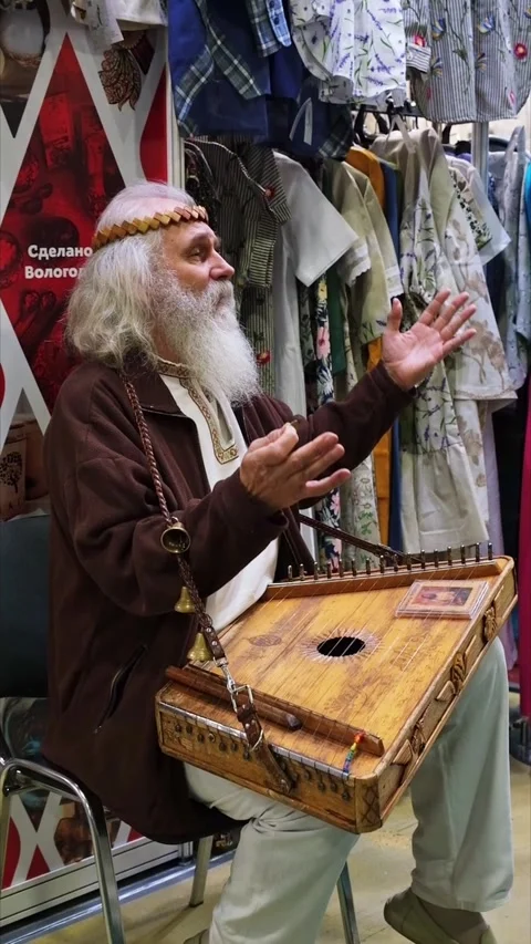An old man guslar plays the harp, an ancient Russian musical instrument Stock Footage 240301423