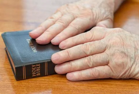 Old man hands on bible Stockfoto's