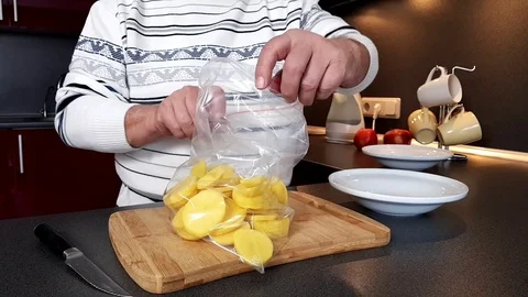 Old man hands close plastic zip packet with cut potatoes Stock Footage 108605098