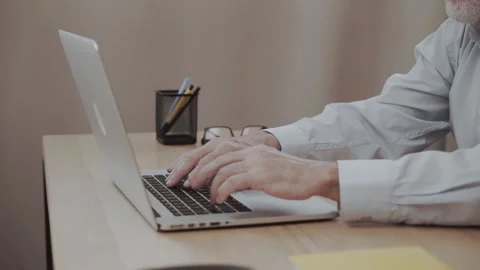 Old man hands over the notebook keyboard typing text message. Difficulty Stock Footage 140875881