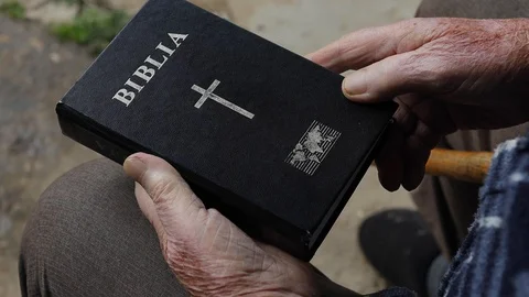 Old man hesitating to open the Bible Stock Footage 127516406