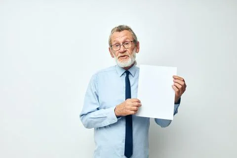 Old man holding documents with a sheet of paper light background Fotos Stock