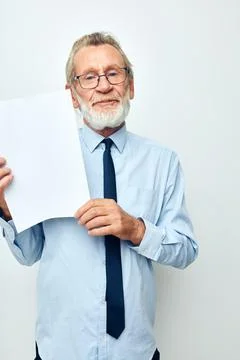 Old man holding documents with a sheet of paper light background Stock Photos