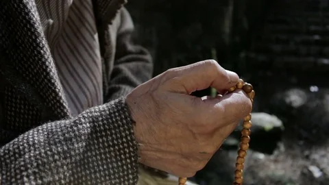 Old man holding prayer beads in hand Video stock 80316925