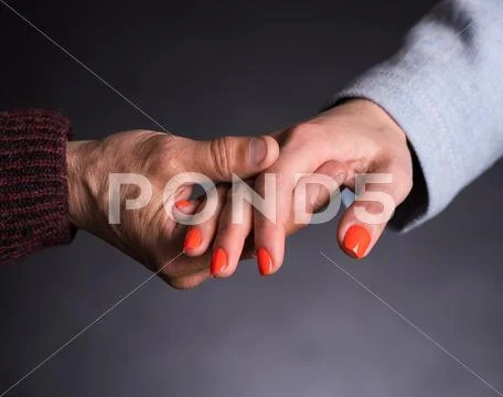 Old man holding young woman's hand Stock Photos