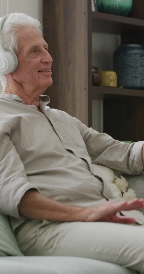 Old man, home and relax with headphones for music, laughing and song selection Stock Footage 334923639