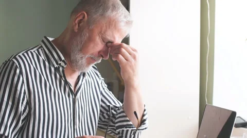 Old man at home with headache in front of laptop at home Stock Footage 113859831