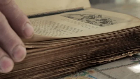 Old man leafing through pages of a very old book. Old book close-up Stock Footage 122263297