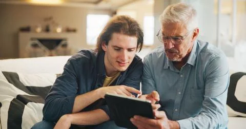 Old man, learning and son with tablet in lounge, skill development and listening Fotos de archivo