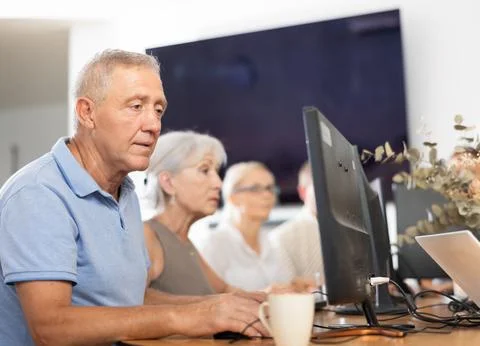 Old man learning computer programs in training room Foto stock