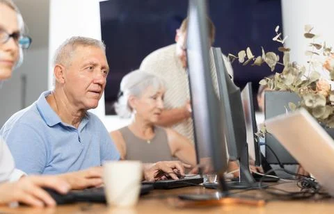 Old man learning computer programs in training room Foto stock