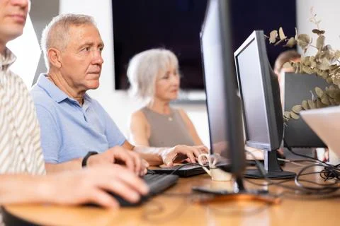 Old man learning computer programs in training room Foto stock
