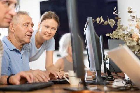 Old man learning computer programs with teacher in training room 写真素材