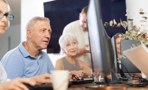 Old man learning computer programs in training room Foto stock