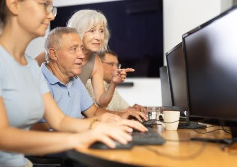 Old man learning computer programs with teacher in training room Foto stock