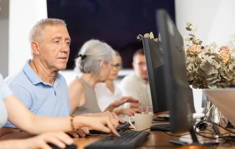 Old man learning computer programs in training room Stock Photos