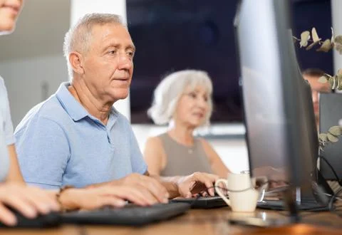 Old man learning computer programs in training room Stock Photos