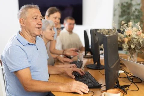 Old man learning computer programs in training room Stock Photos