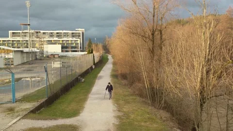 Old man limping on walking path with a cane. Video stock 149400813
