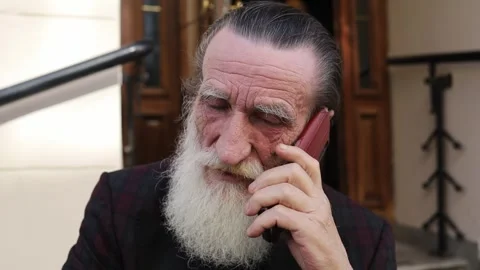 Old man with long flowing beard talking on phone outdoors in fresh air 스톡 동영상 312186474