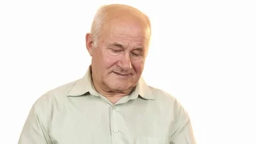 Old man looking at an alarm clock smiling to the camera 動画素材 85893268