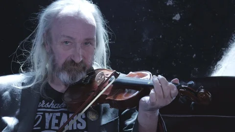 Old man looking at camera playing violin Stock Footage 111660498