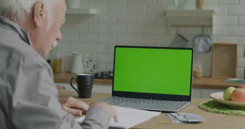 Old man looking at chroma key green screen and reading payment documents with Vídeo Stock 242358100