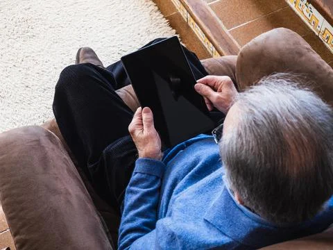 Old man looking a tablet in house Stock Photos
