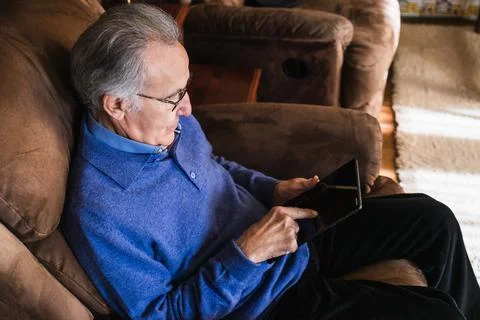 Old man looking a tablet in house Stock Photos