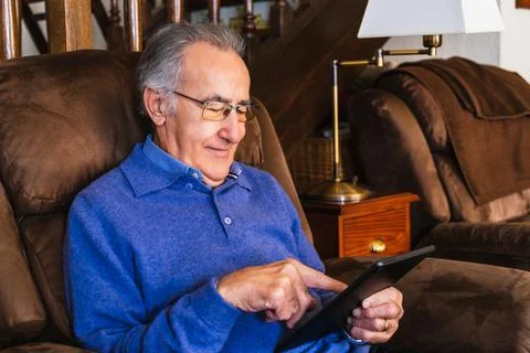 Old man looking a tablet in house Stock Photos