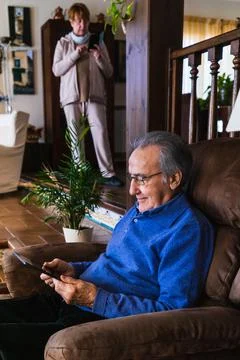 Old man looking at tablet in sofa Stock Photos