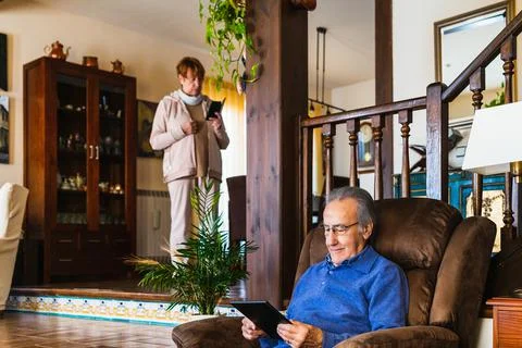 Old man looking at tablet in sofa Stock Photos