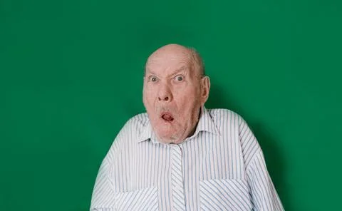An old man makes faces at an isolated green background. chromakey Stock Photos