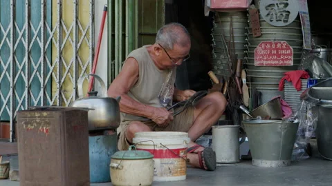 An old man making and selling handmade products on the street in Malacca Stock Footage 135176988