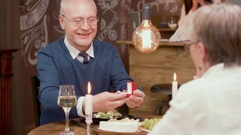 Old man making a proposal to his partner on a romantic dinner Stock Footage 106453096