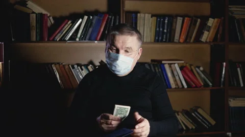 Old man in mask pulls money out of wallet poor Stock Footage 148268189