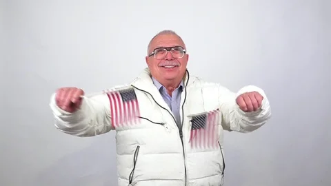 Old man with mustache in jacket poses smiles waving US flags 動画素材 107892401