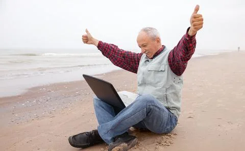 Old man with notebook on beach Stock Photos