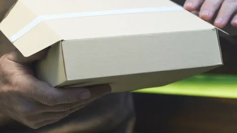 Old man opening cardboard box with letter, received parcel from children Stock Footage 99891296