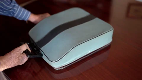 Old man opening grey suitcase with vintage typewriter machine, retro antiques Stock Footage 147614598