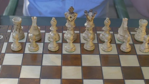 Old man opens the chess game with white pawn on E4 Stock Footage 118711965
