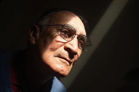  Old man or elder model with glasses with his face illuminated in the dark, blac Stock Photos