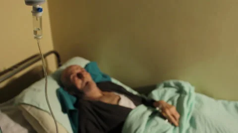 Old man, patient lying down on bed in hospital rum. Infusion close up. Stock Footage 34630950