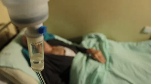 Old man, patient lying down on bed in hospital rum. Infusion close up.;;; Video stock 34634365