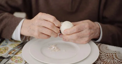 Old Man Peeling Egg on Plate Stock Footage 126799243
