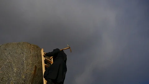 Old man with pickaxe climbing up to rock slow motion Stock Footage 104490552