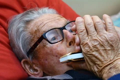 Old man play harmonica Stock Photos